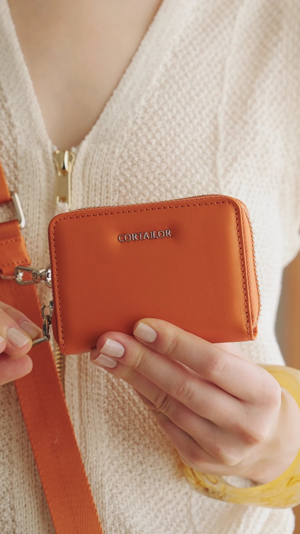 Orange CORTAILOR MagSafe Leather Wallet Stand holding an iPhone in stand mode on a desk