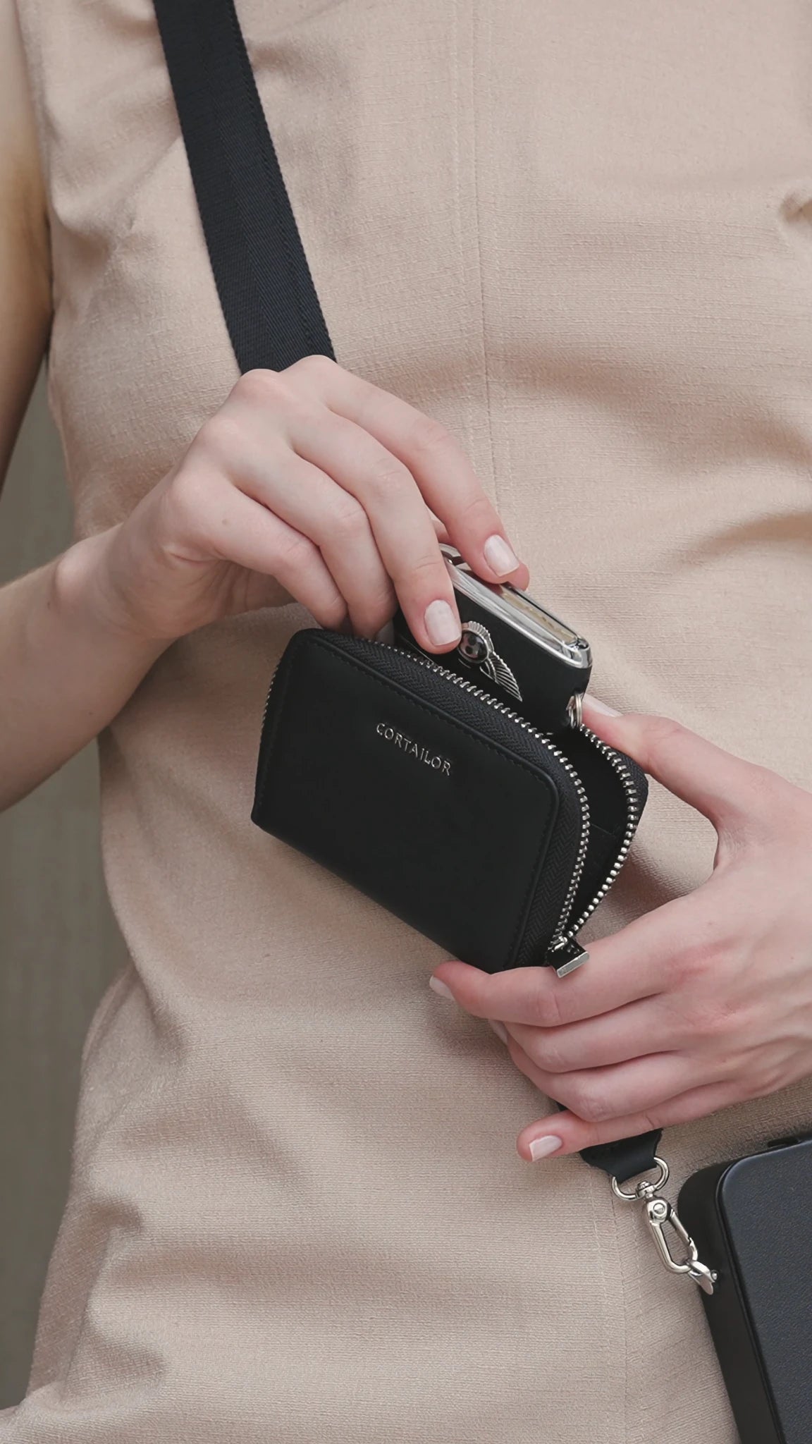 Orange CORTAILOR MagSafe Leather Wallet Stand attached to an iPhone case while a card is being pulled out in a cafe