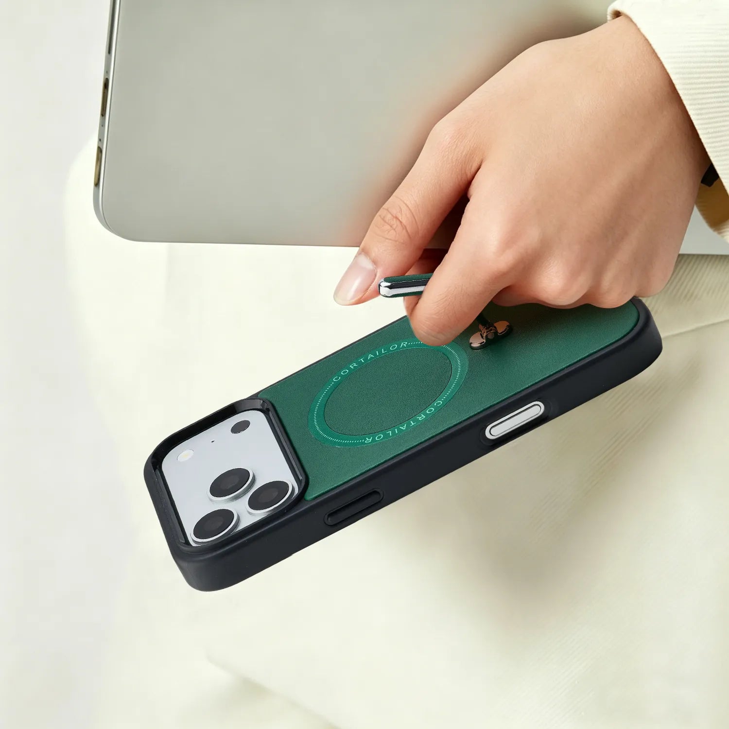 Green CORTAILOR Kickstand Leather MagSafe iPhone Case with built-in metal stand being pulled out by hand