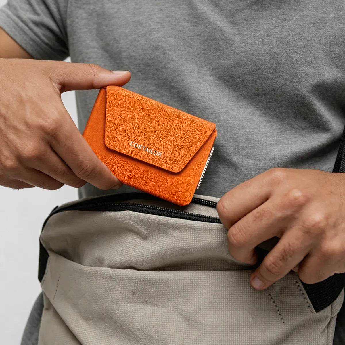 Orange CORTAILOR MagSafe Leather Wallet Stand being placed into a daily carry bag