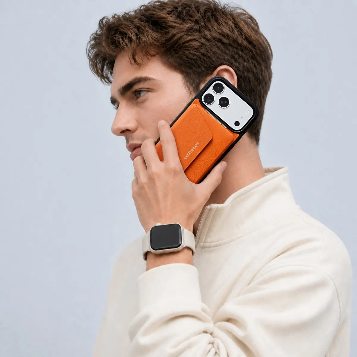Orange CORTAILOR MagSafe Leather Wallet Stand attached to an iPhone case while being used for a phone call