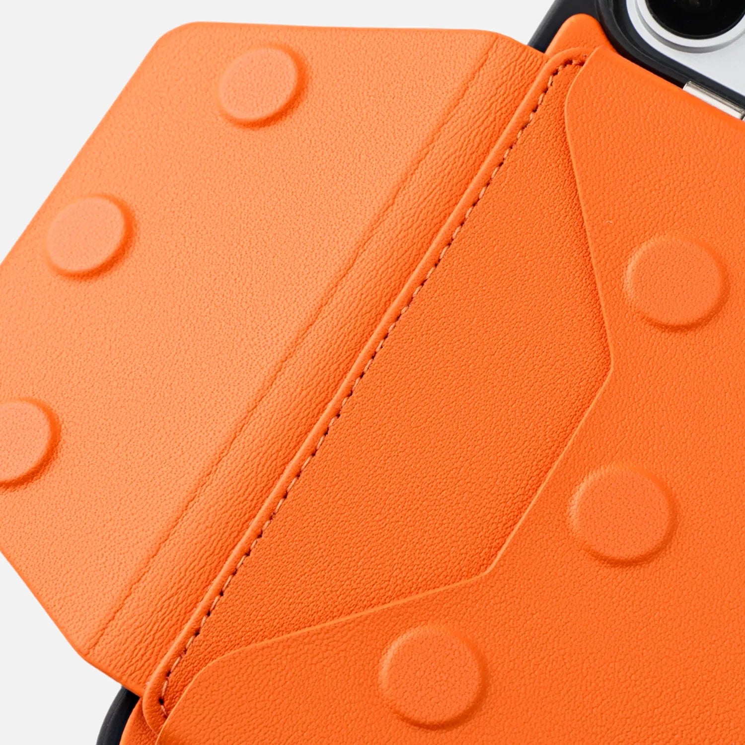 Orange CORTAILOR MagSafe Leather Wallet Stand attached to an iPhone case while a card is being pulled out in a cafe