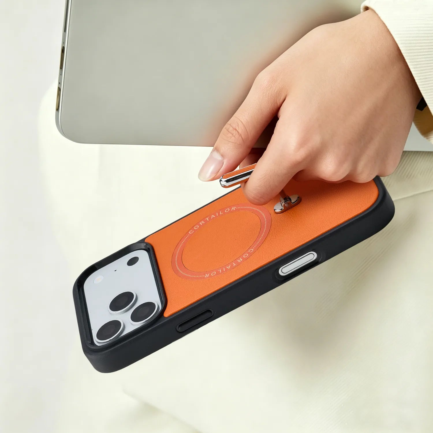 Orange CORTAILOR MagSafe Leather Wallet Stand being placed into a daily carry bag