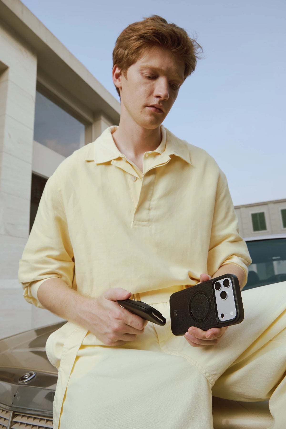 Orange CORTAILOR MagSafe Leather Wallet Stand holding an iPhone in stand mode on a desk